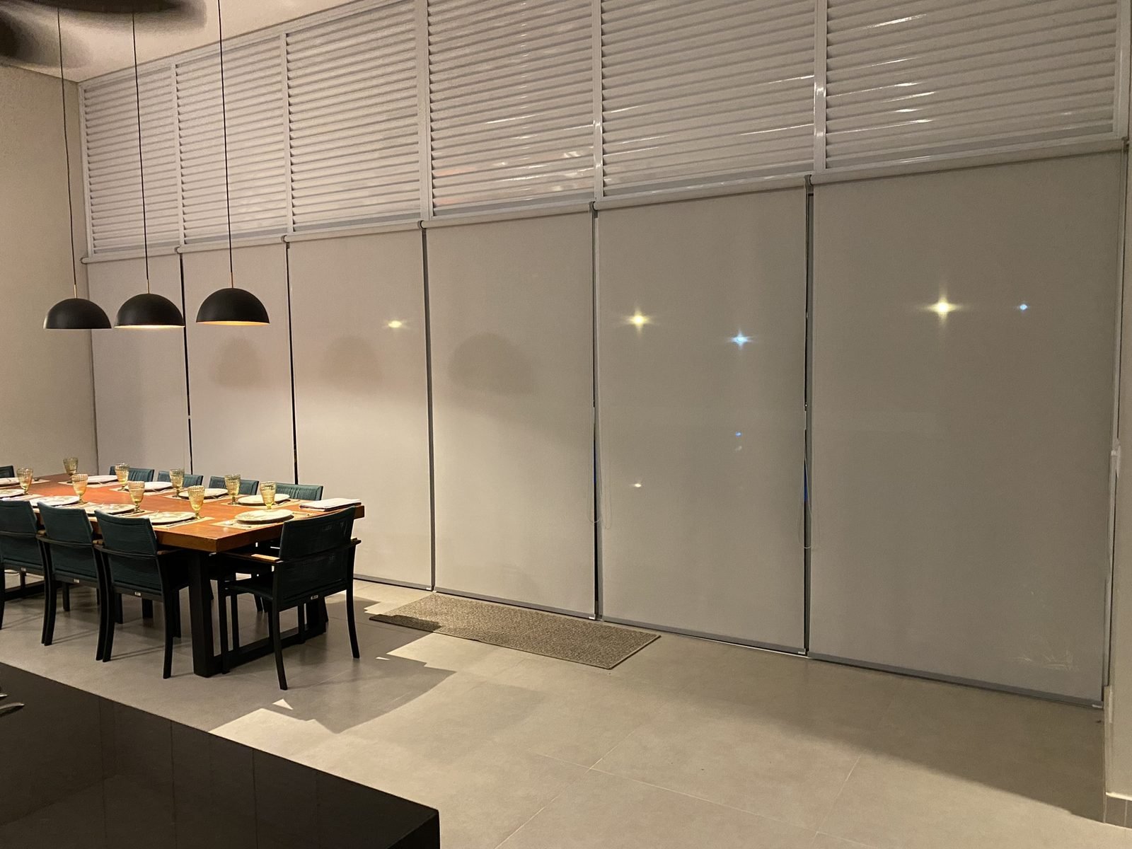Espaço gourmet com cortinas rolô claras nas janelas