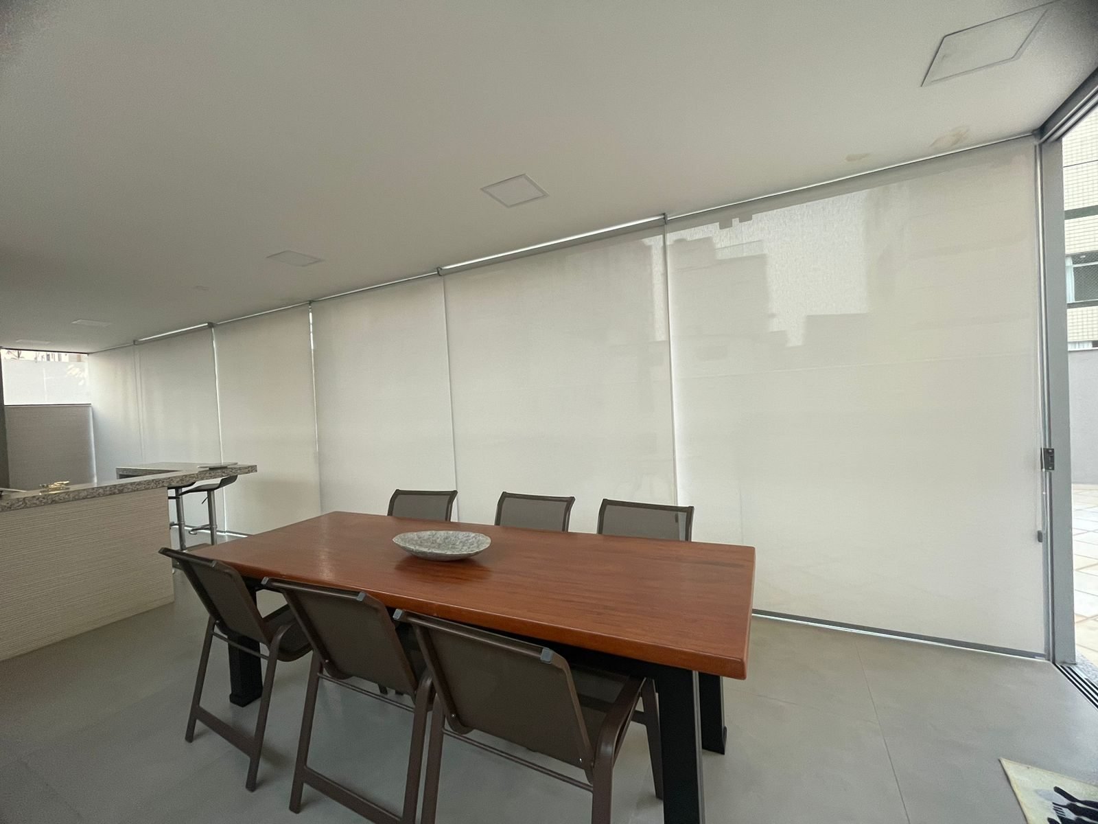 Varanda gourmet com cortinas rolô em tela solar com proteção UV
