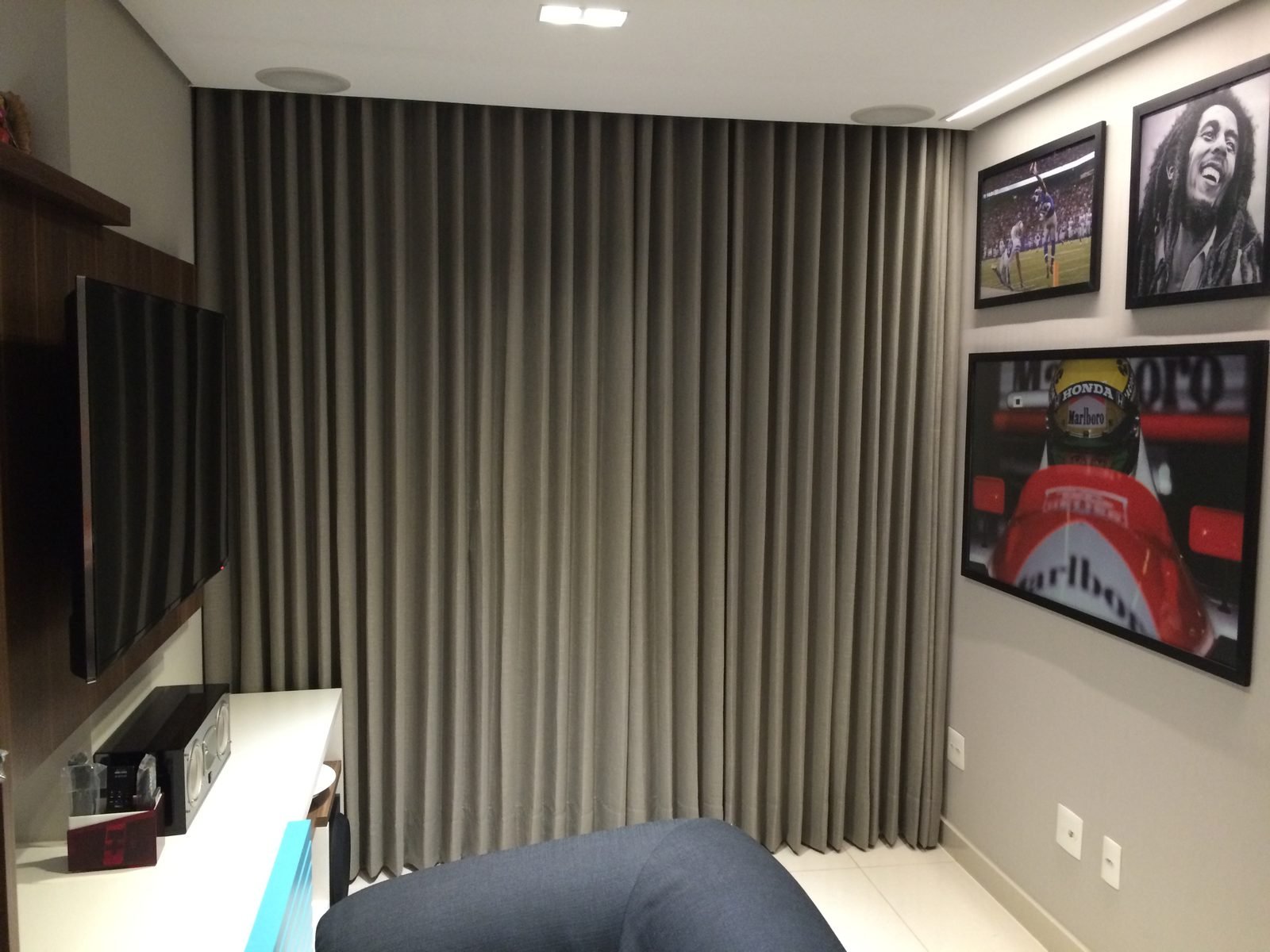 Sala de TV com cortina wave cinza cobrindo toda a parede de janelas
